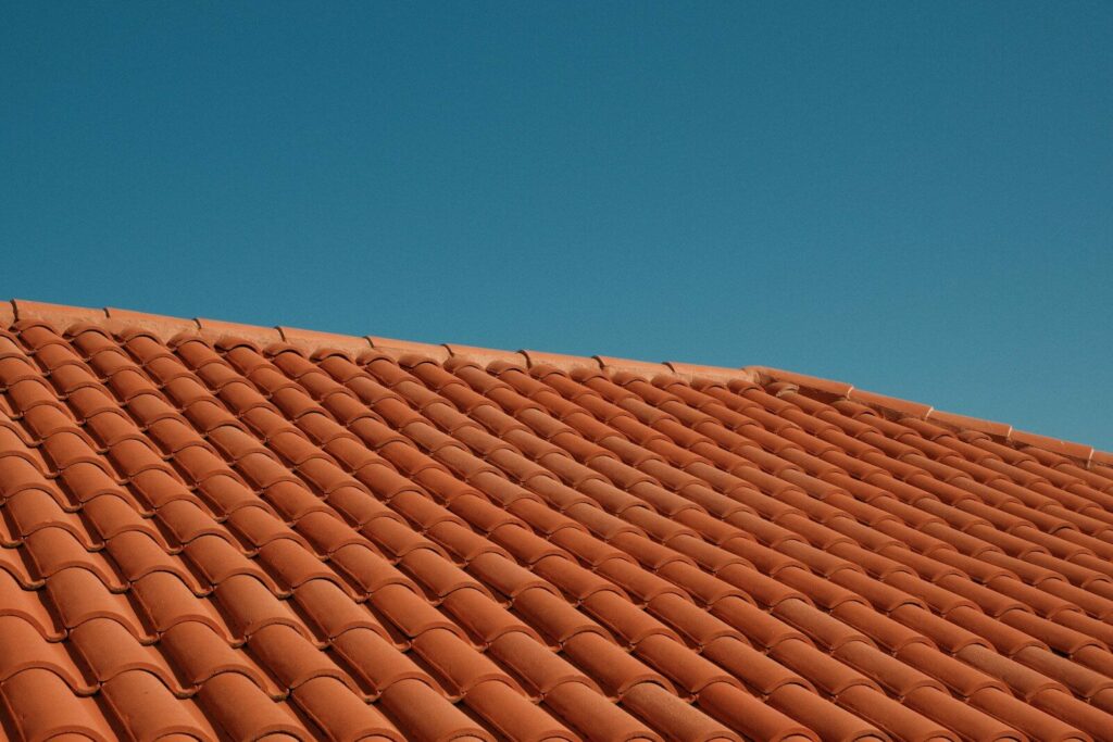 Red clay roof tiles against a clear blue sky